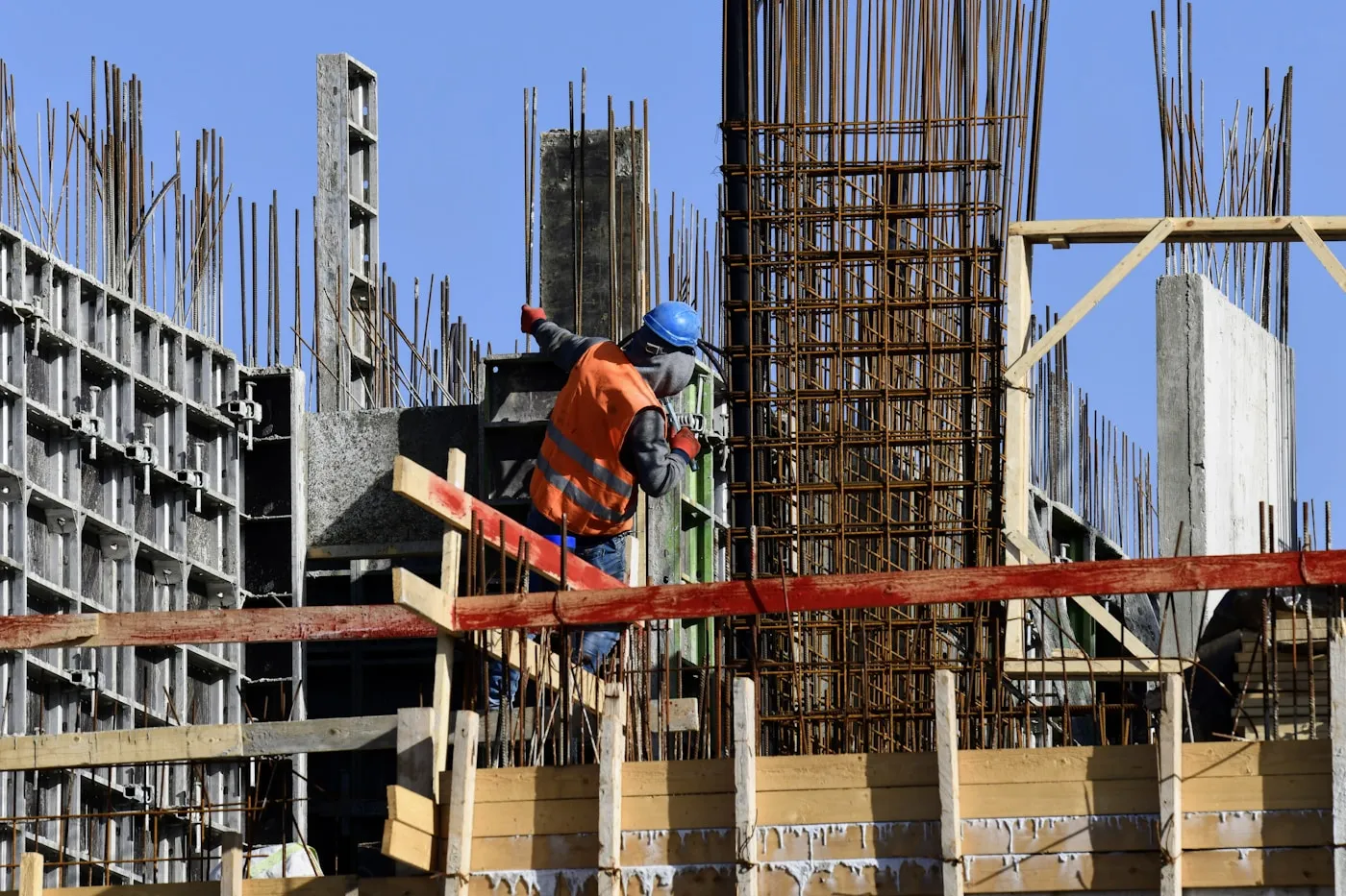 Operarios trabajando sobre una estructura en obra nueva.